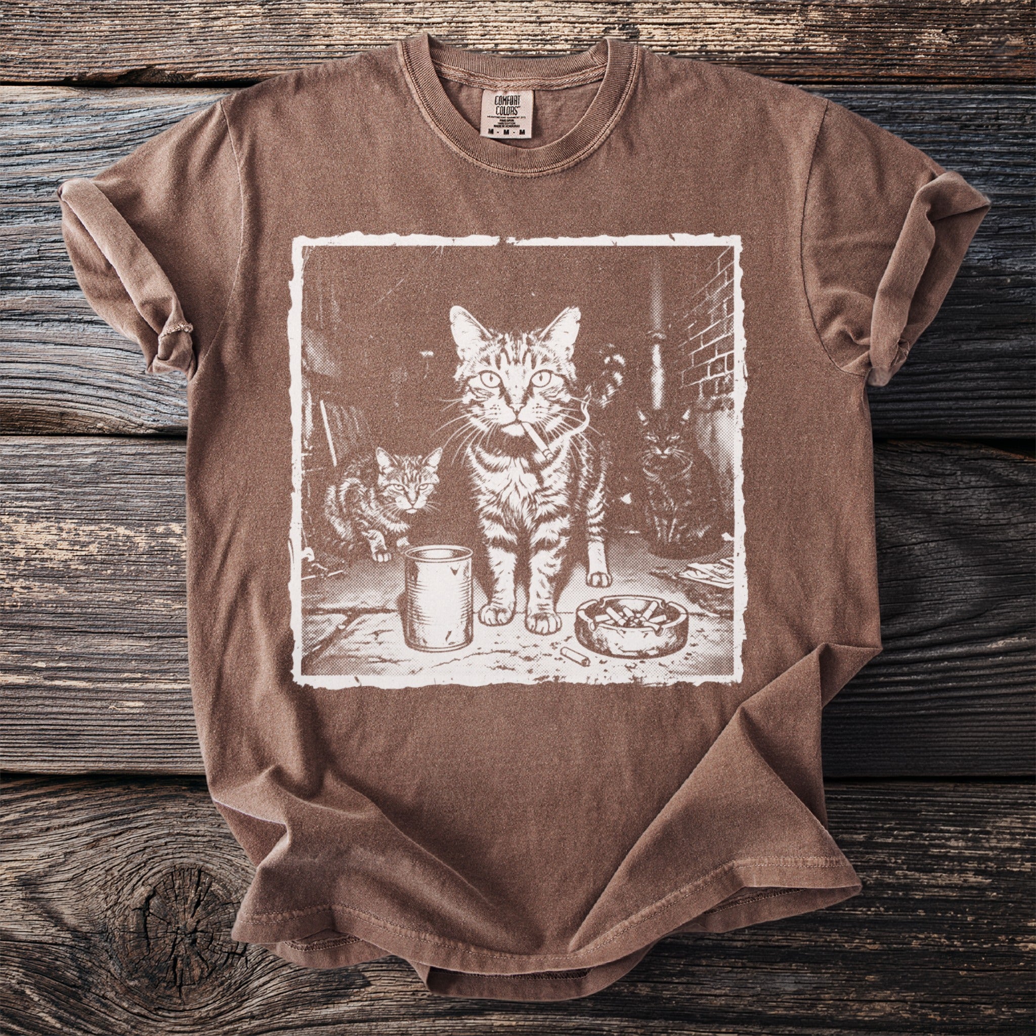 T-shirt featuring a graphic of three cats, one with a cigarette, and an ashtray.