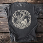 T-shirt with a circular graphic of a robed figure, bull, and tree under a moon.