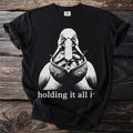 Black t-shirt with a graphic of a pelican holding fish in its beak and text.
