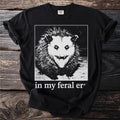 Black t-shirt with a graphic of a feral opossum and text "in my feral er".