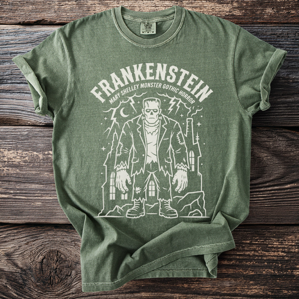 Green t-shirt with white Frankenstein monster design and text "Frankenstein Mary Shelley Monster Gothic Horror".