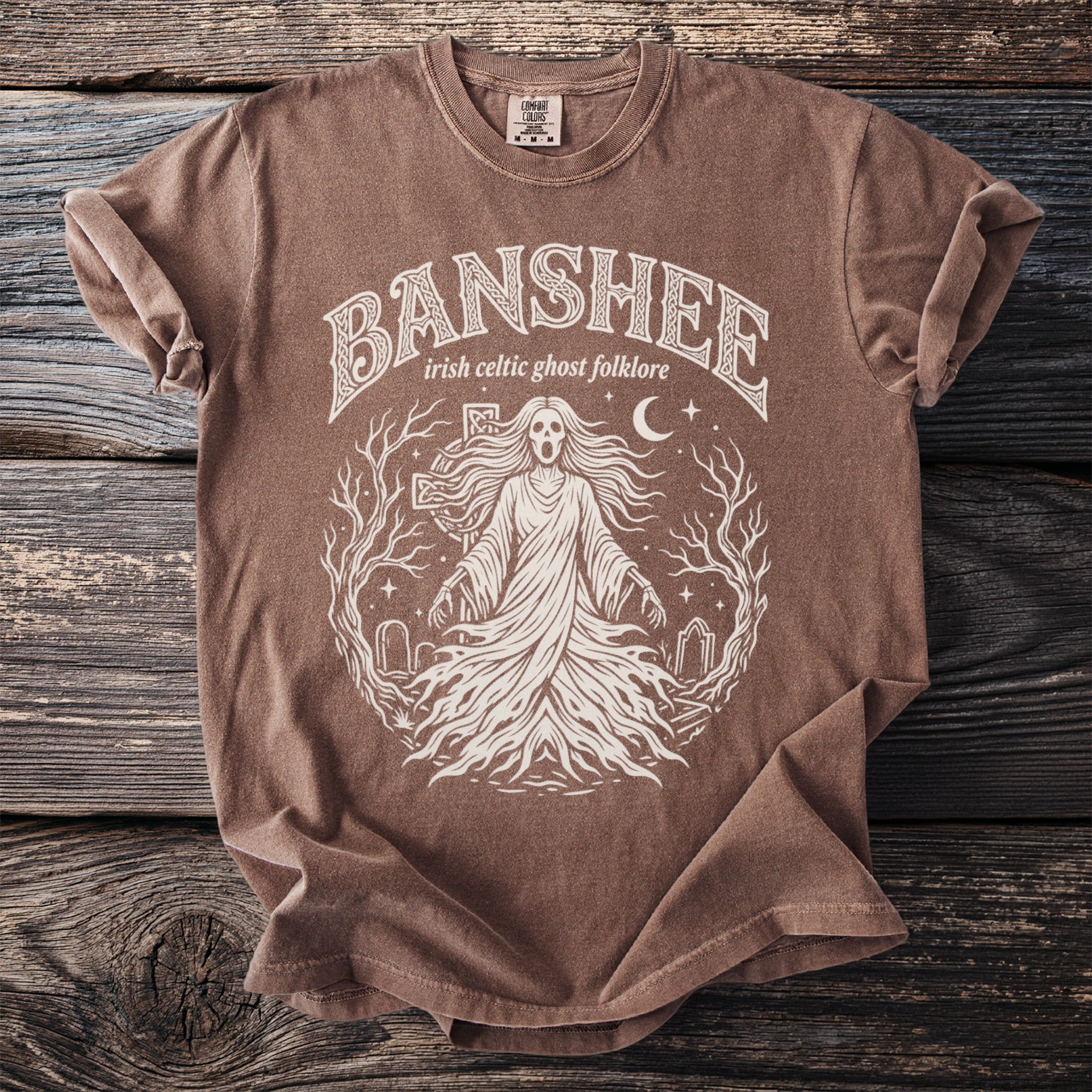 Brown t-shirt with white text and graphic of a Banshee in Irish Celtic folklore.