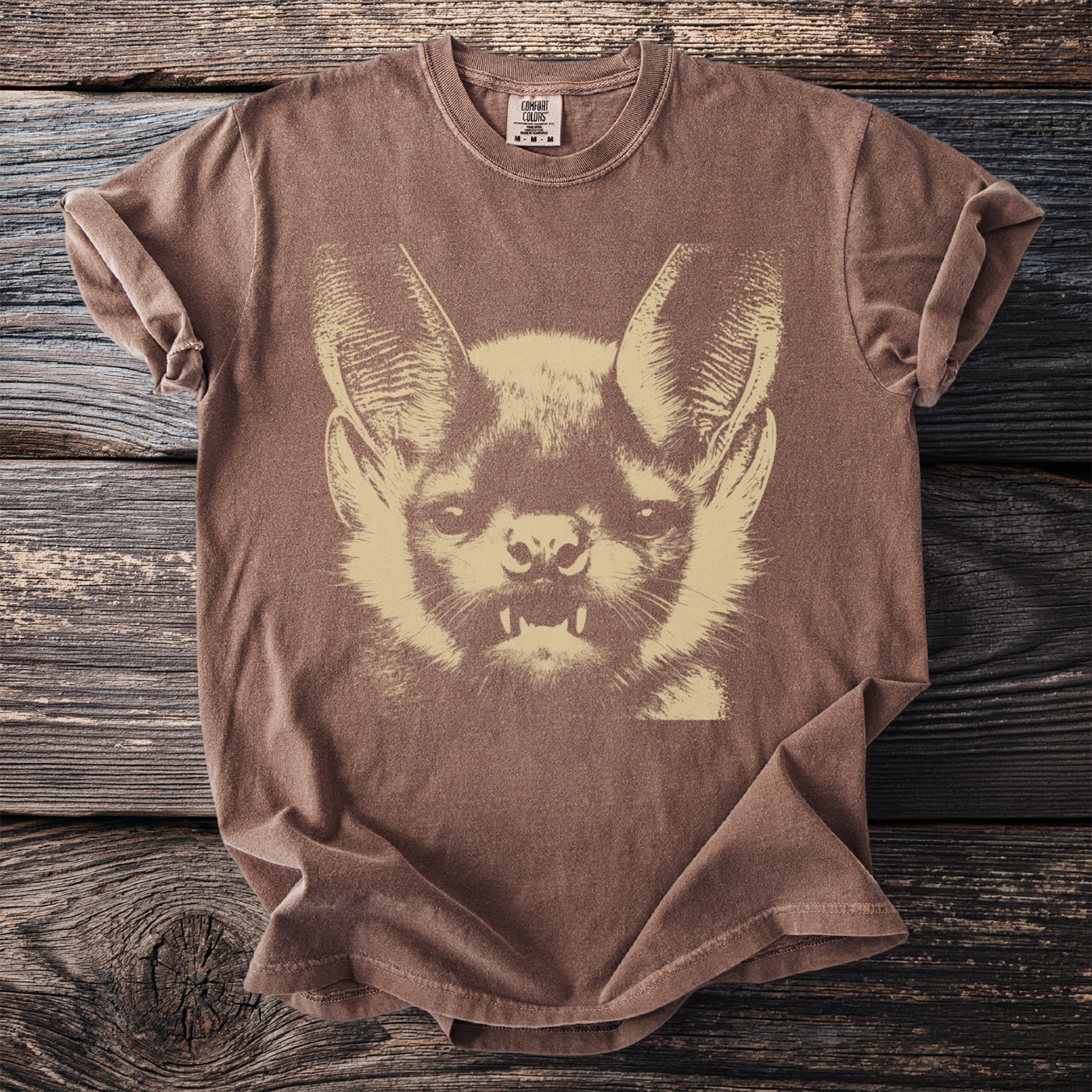 Brown t-shirt with a light brown graphic of a bat's face.