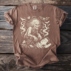 Brown t-shirt with a cream graphic of a decaying figure looming over a sleeping person.