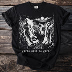 Black t-shirt with a print of spectral figures in a cornfield at night and the text "girls will be girls".
