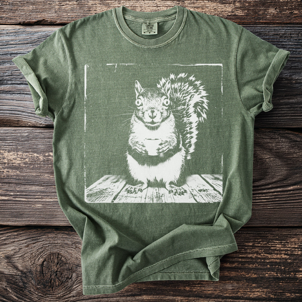 Green Comfort Colors t-shirt with a distressed white graphic of a squirrel holding a cup.