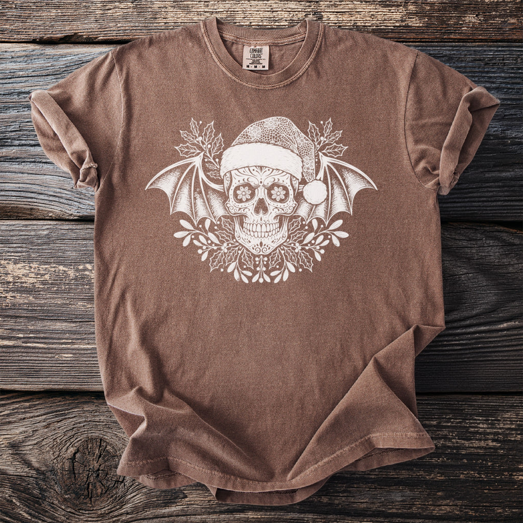 Brown t-shirt with white sugar skull, bat wings, and holiday holly design.