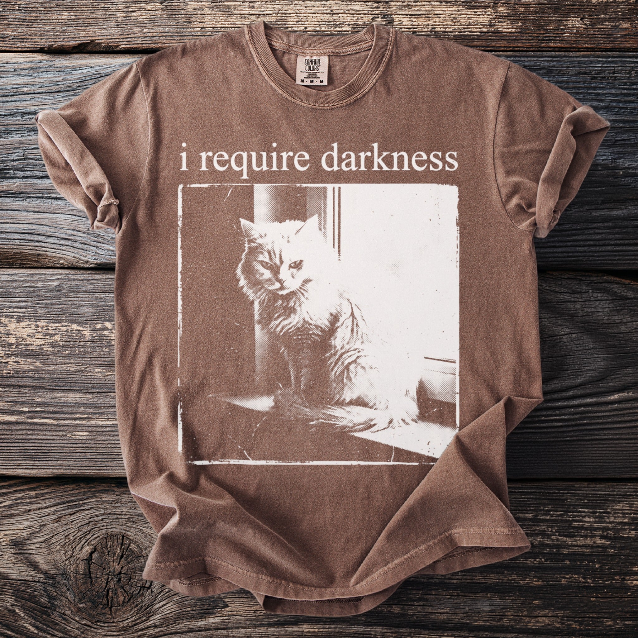Brown t-shirt with "i require darkness" and cat graphic.