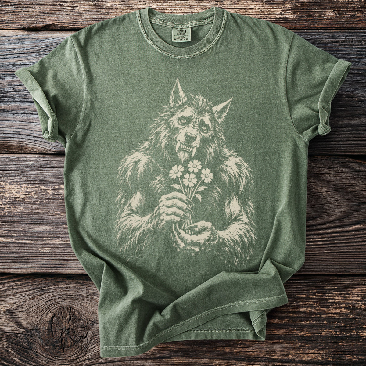 Green t-shirt with a cream graphic of a werewolf holding a bouquet of flowers.