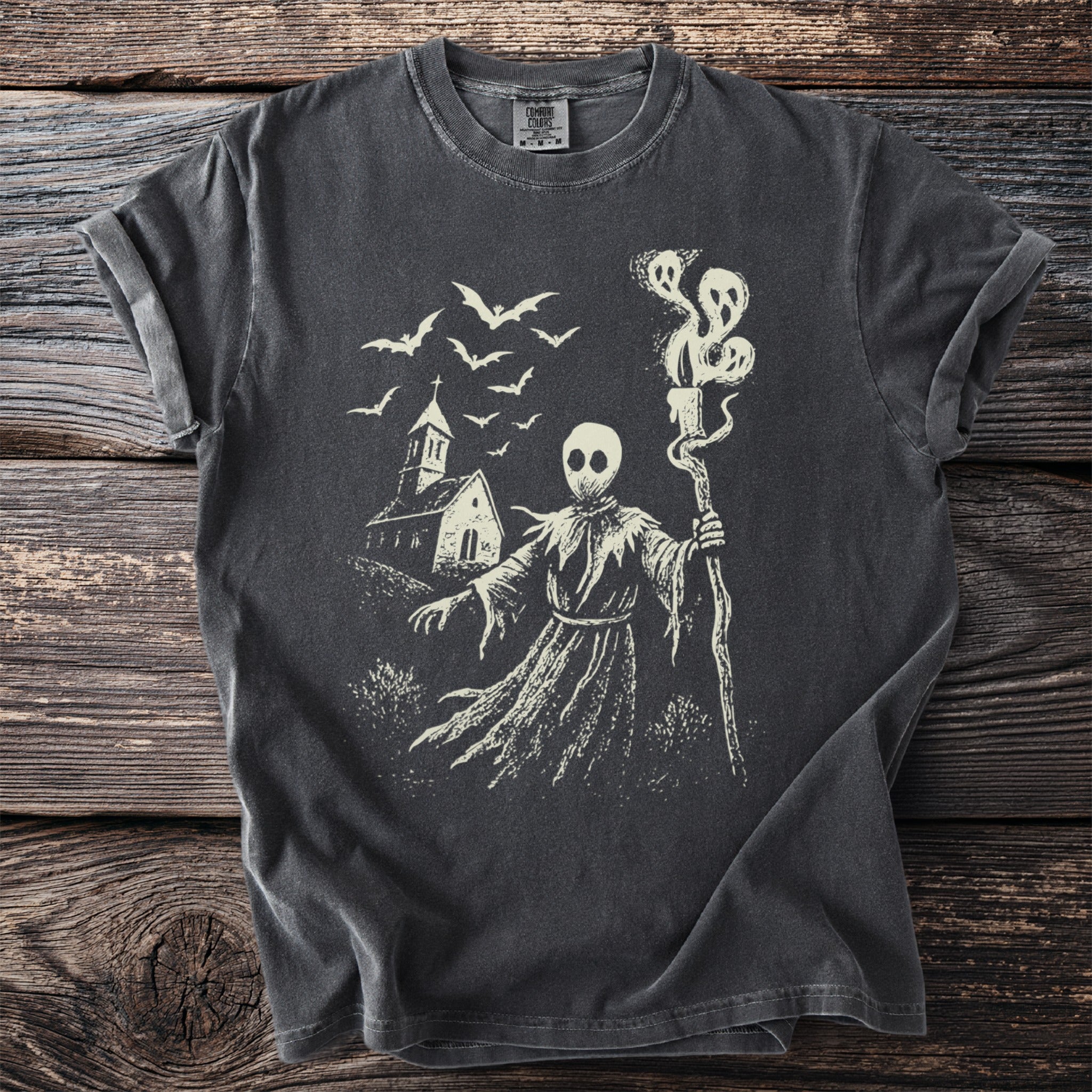 Dark grey t-shirt with a cream graphic of a grim reaper, church, and bats.