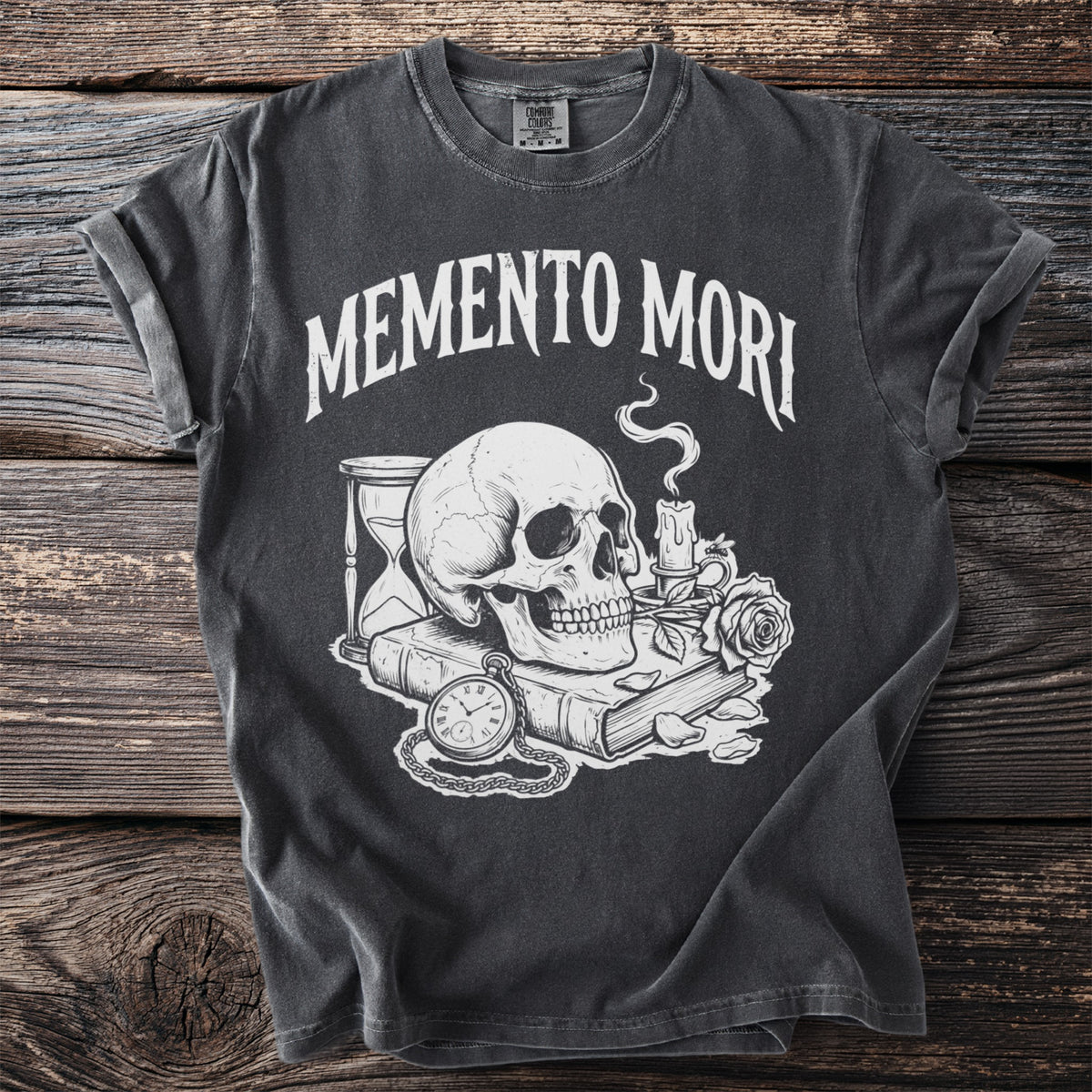 Dark t-shirt with "Memento Mori" text and skull with candle, book, and hourglass.