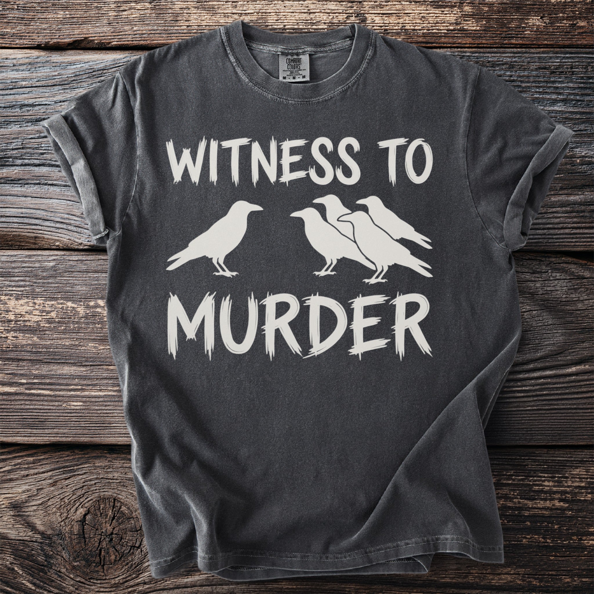 Dark grey t-shirt with white text "WITNESS TO MURDER" and a murder of crows graphic.