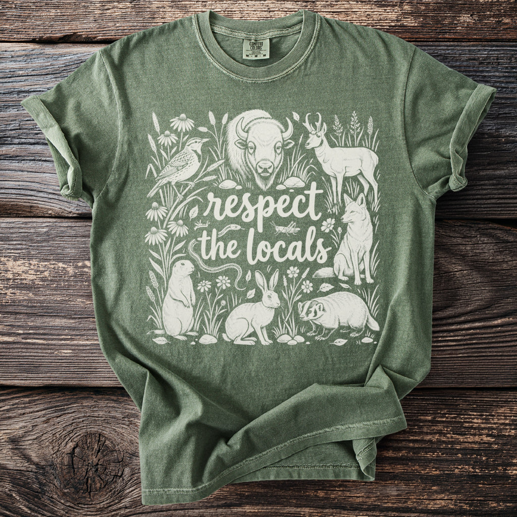 Green Comfort Colors t-shirt with white wildlife illustration and text "respect the locals."