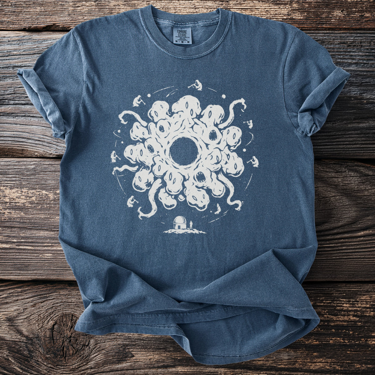 Blue t-shirt with a white circular graphic of tentacles, eyes, mouths, and figures.