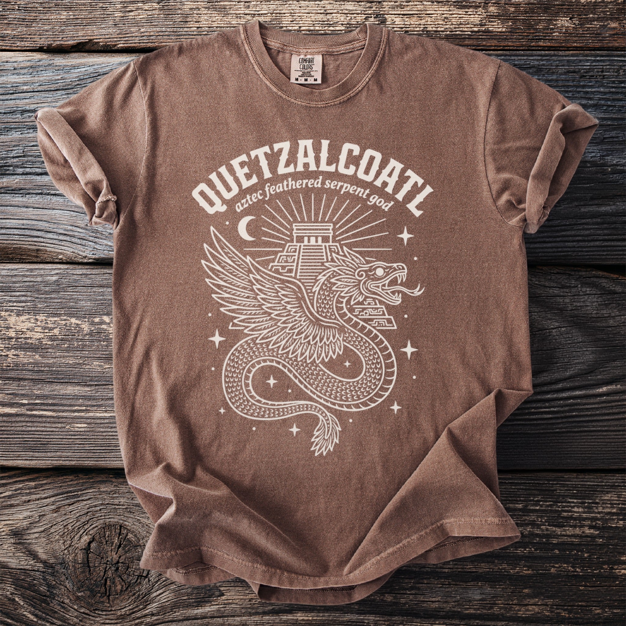 Brown t-shirt with Quetzalcoatl Aztec feathered serpent god graphic and Comfort Colors tag.