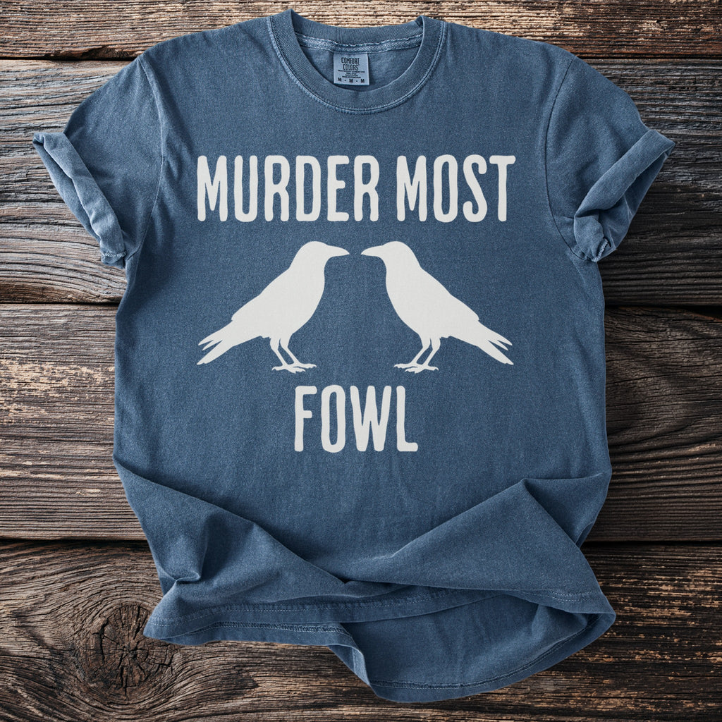 Blue t-shirt with white text "MURDER MOST FOWL" and two silhouette crows.