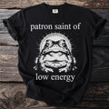 Black t-shirt with a toad graphic and text saying "patron saint of low energy".