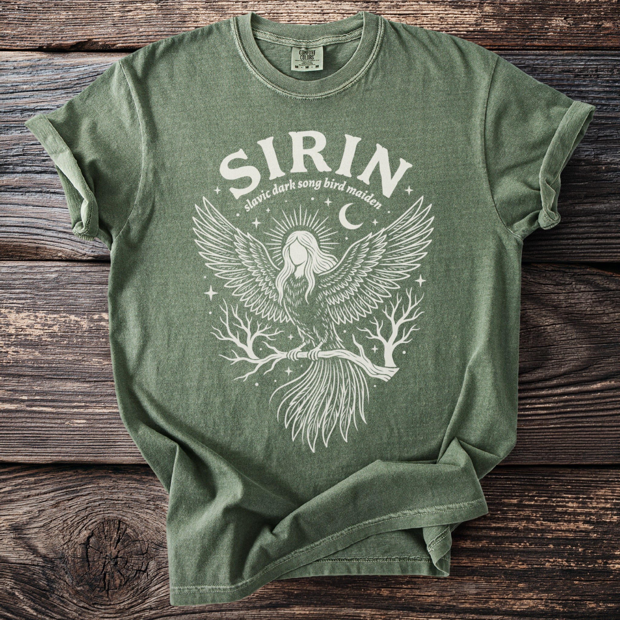 Green t-shirt with white graphic featuring a bird-woman and text "SIRIN Slavic dark song bird maiden".
