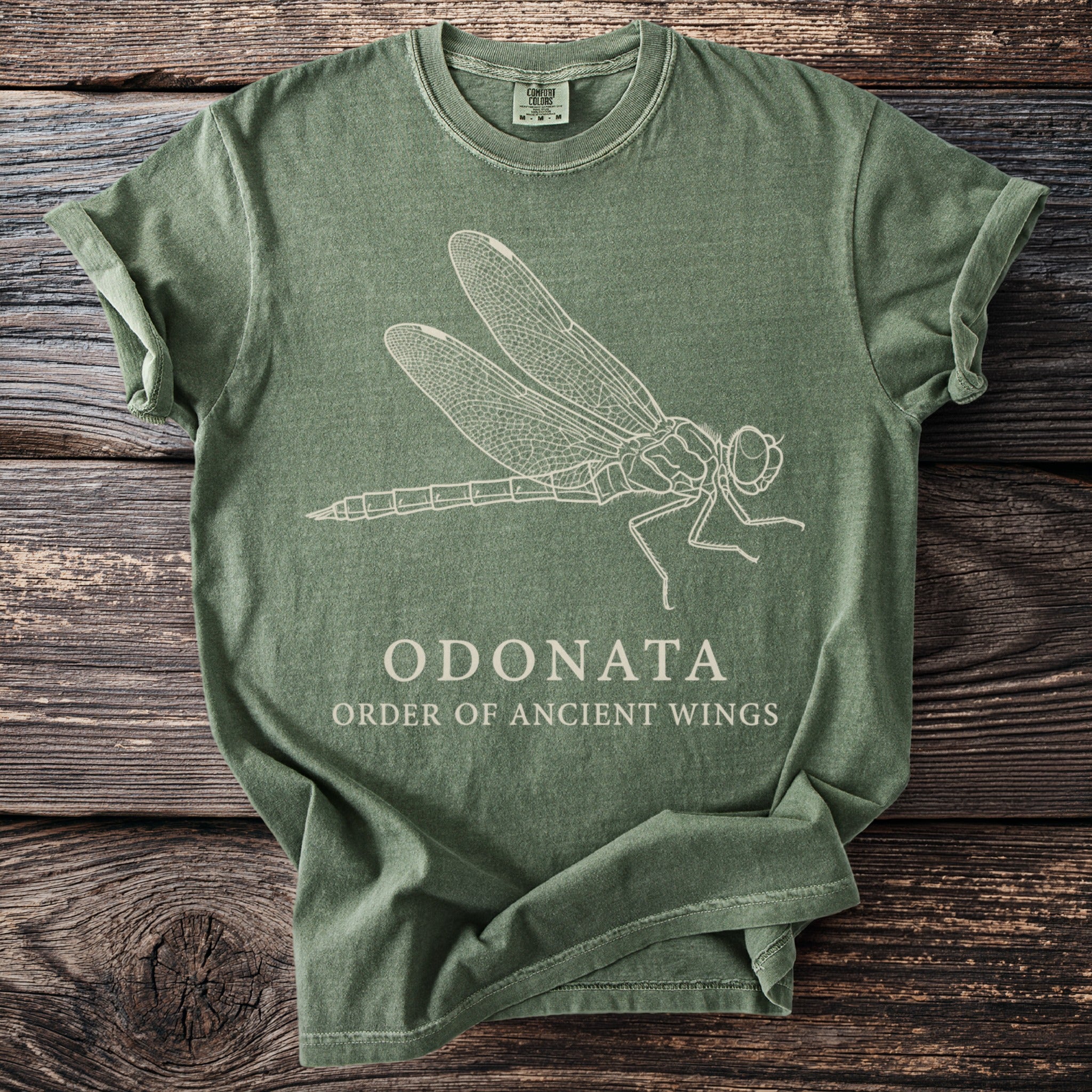 Green t-shirt with a white line drawing of a dragonfly and text "ODONATA ORDER OF ANCIENT WINGS".