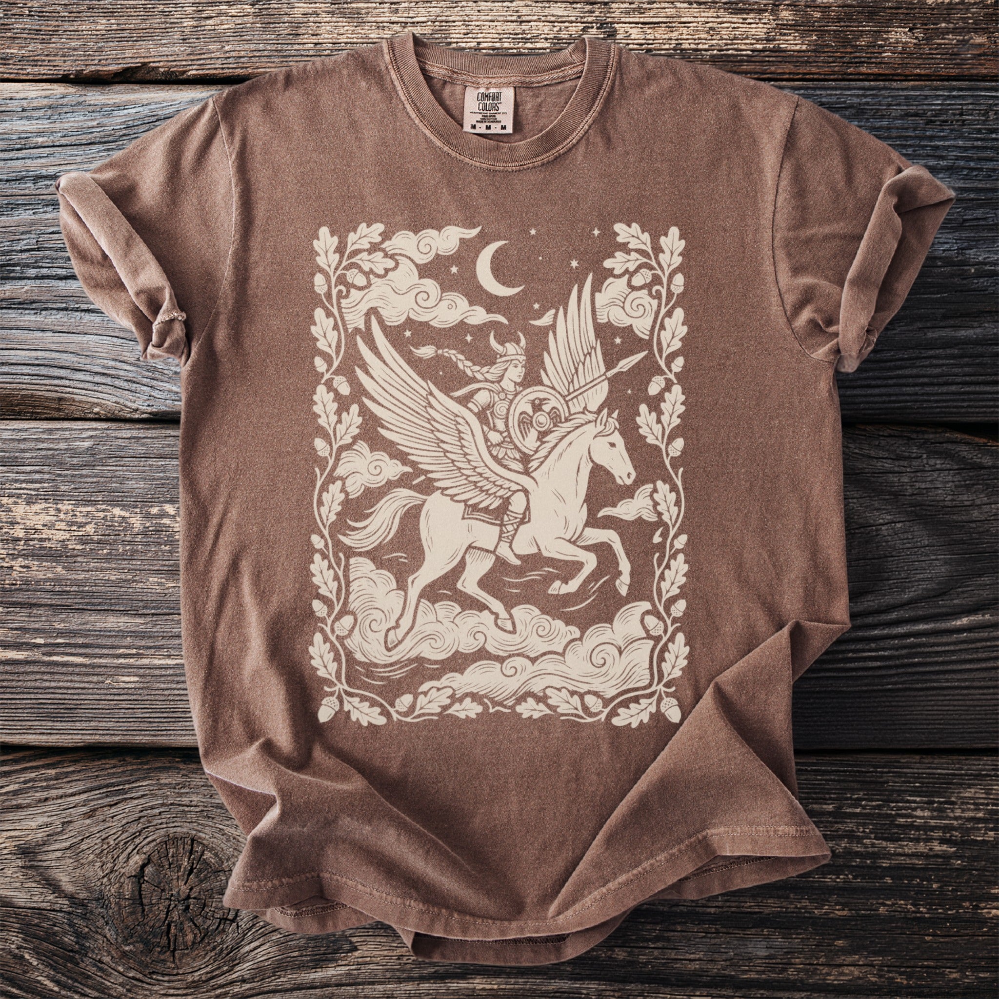 Brown t-shirt with a cream graphic of a winged woman riding a pegasus.