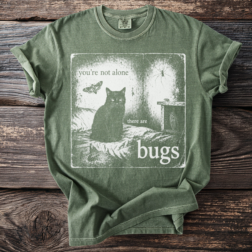 Green t-shirt graphic: black cat, moth, spider, and bugs with text "you're not alone there are bugs".