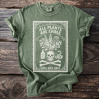 Green t-shirt with a vintage print of a skull, bouquet, poison bottle, snake, and bones.