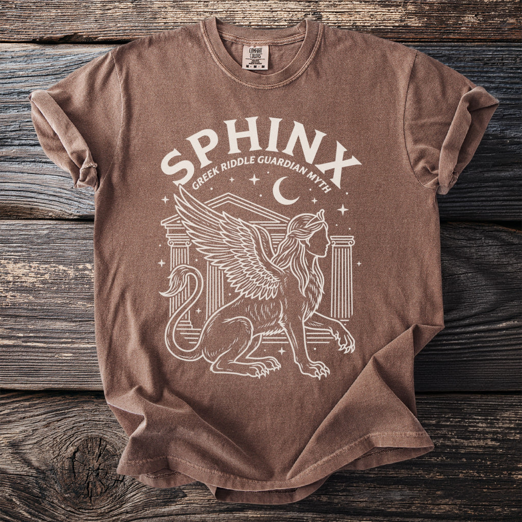 Brown t-shirt with white graphic of a sphinx, columns, moon, and stars.