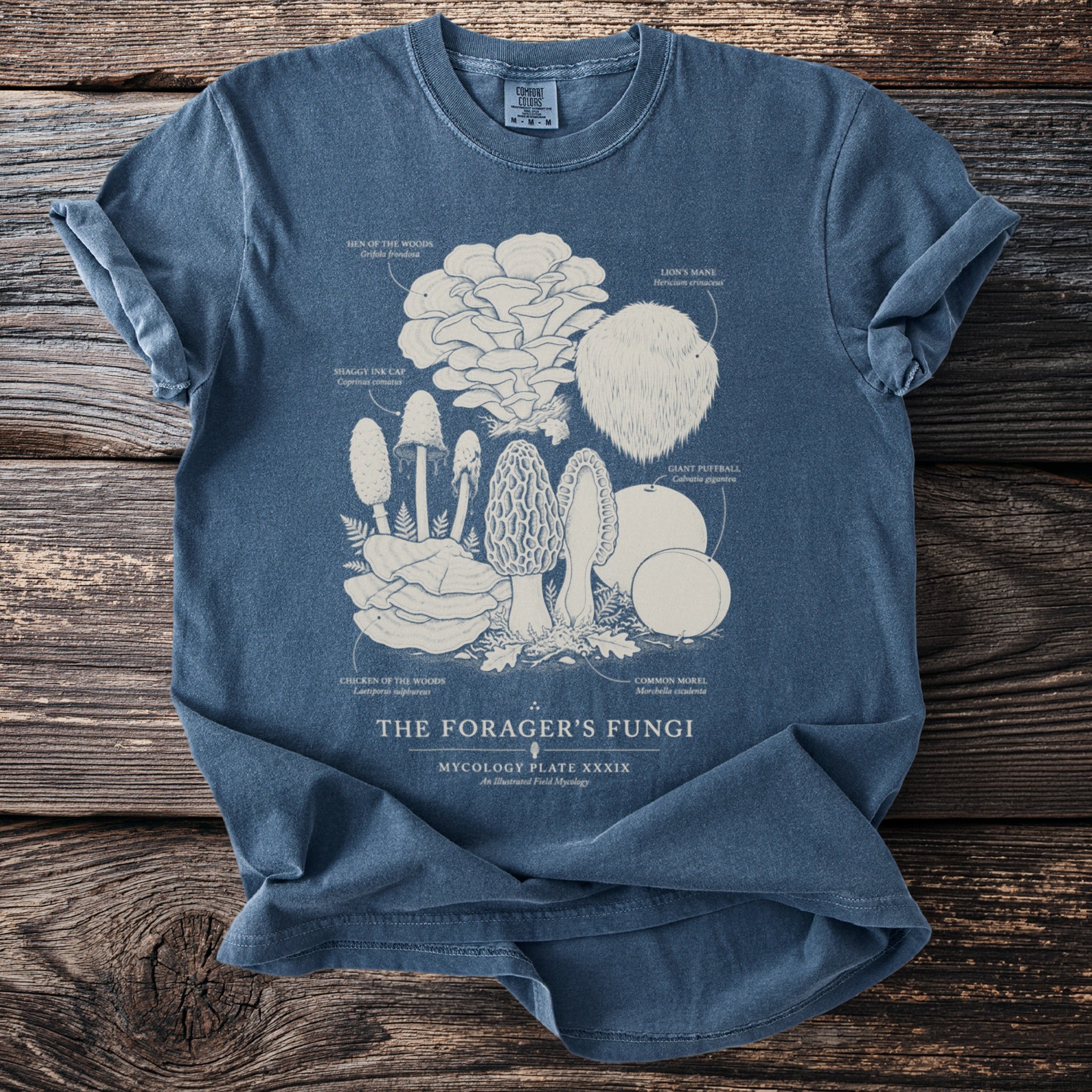 Blue t-shirt featuring an illustration of various fungi labeled "The Forager's Fungi".