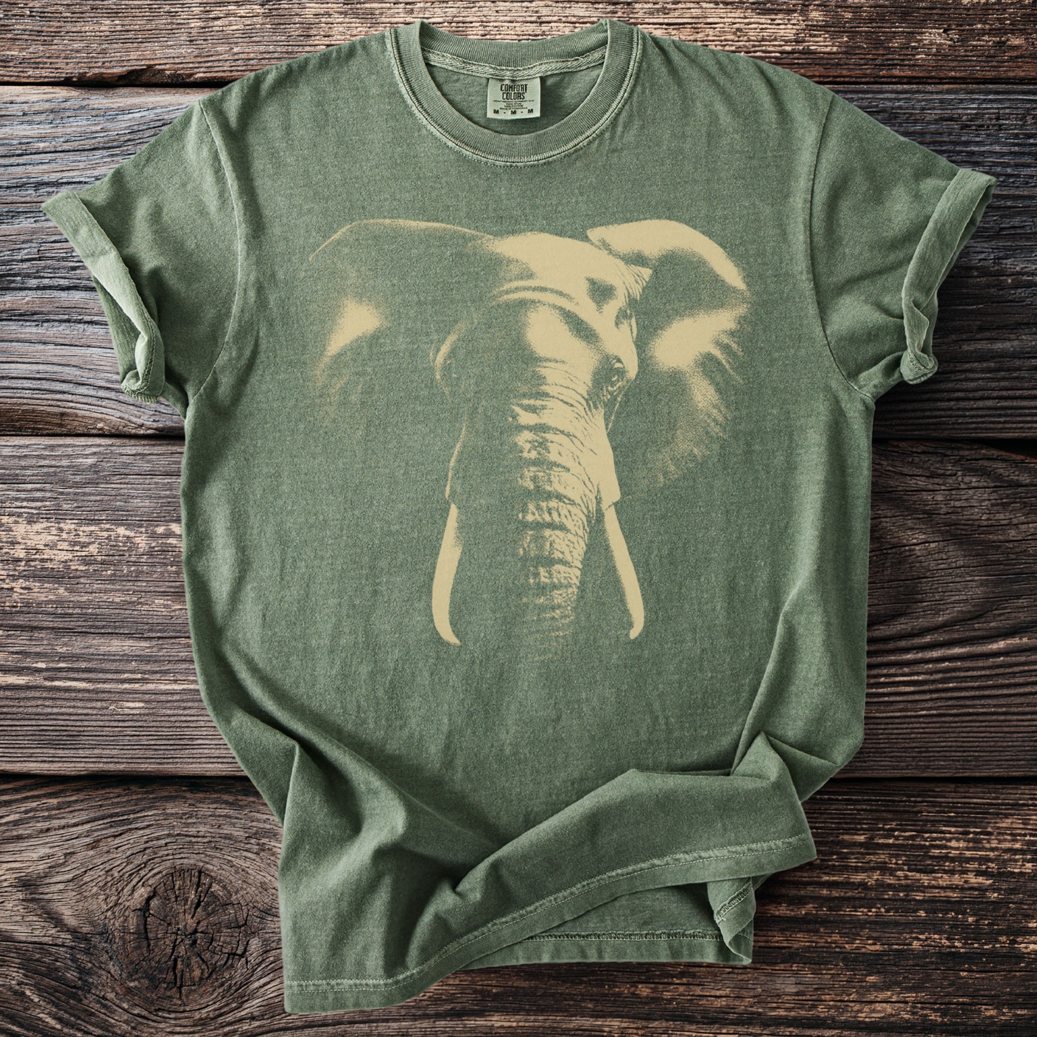 Green t-shirt with a faded graphic of an elephant's head and tusks.