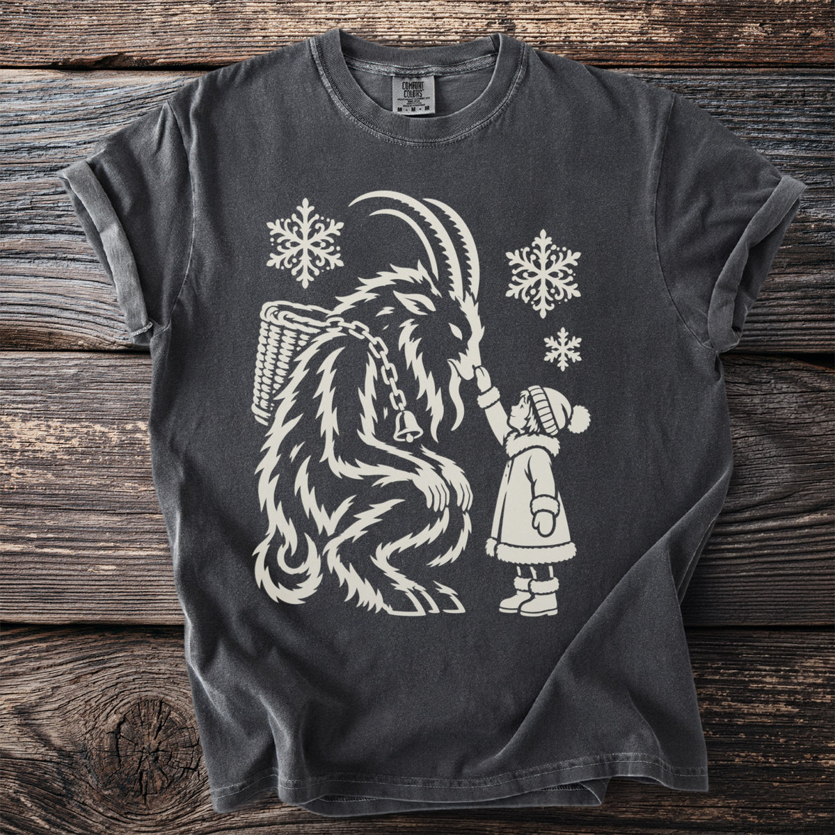 Dark grey t-shirt with a cream graphic of Krampus and a child with snowflakes.