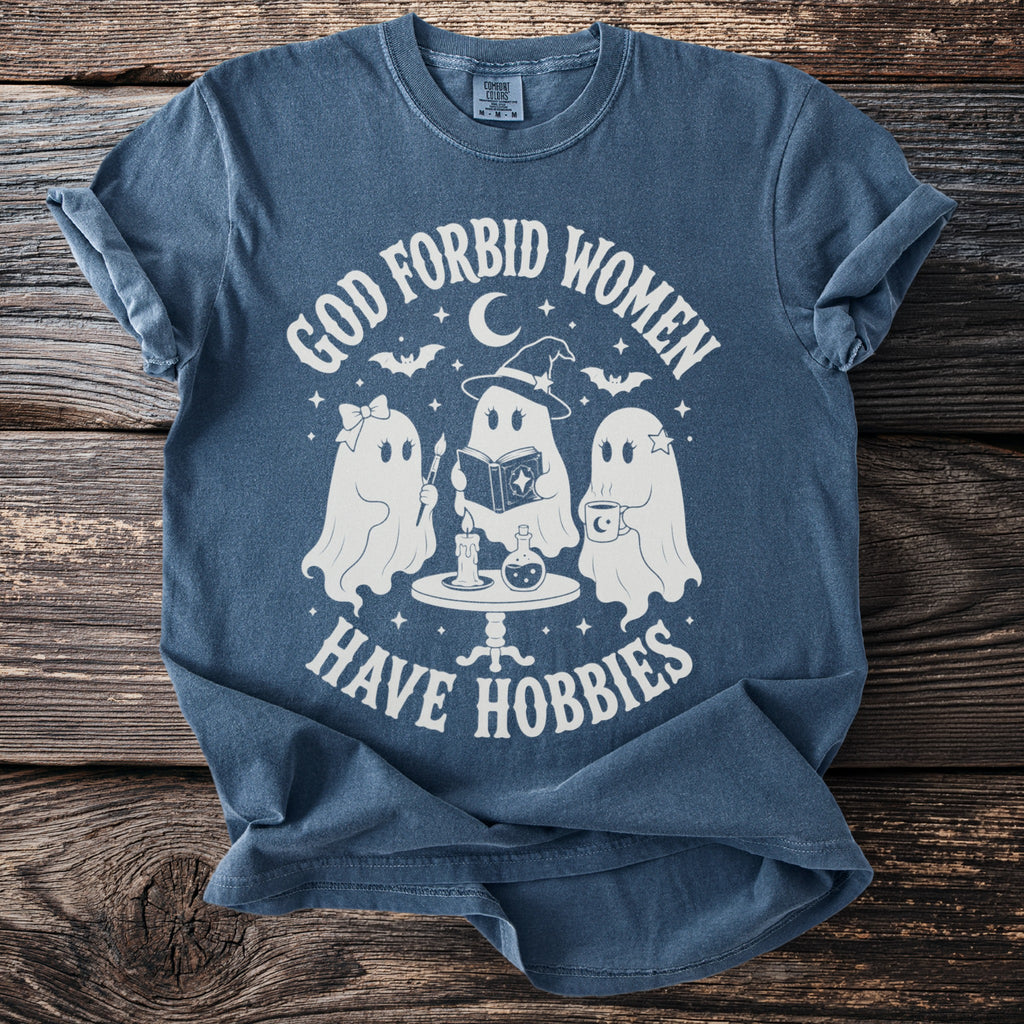 Blue t-shirt with white graphic of three ghosts and the text "God forbid women have hobbies."