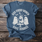 Blue t-shirt with white graphic of three ghosts and the text "God forbid women have hobbies."