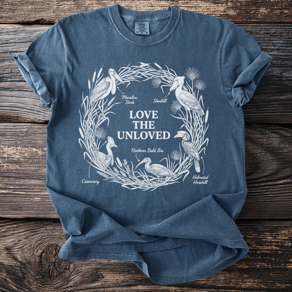 Blue t-shirt with "Love the Unloved" and birds: Marabou Stork, Shoebill, Northern Bald Ibis, Helmeted Hornbill, Cassowary.