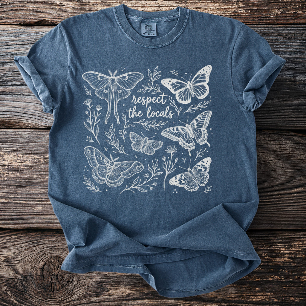 Blue t-shirt with white outline drawing of butterflies and text "respect the locals".