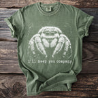 Green t-shirt with white graphic of a jumping spider and text "i'll keep you company".