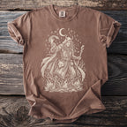 Brown t-shirt with a pagan graphic of a woman with a snake and fox on a wooden background.