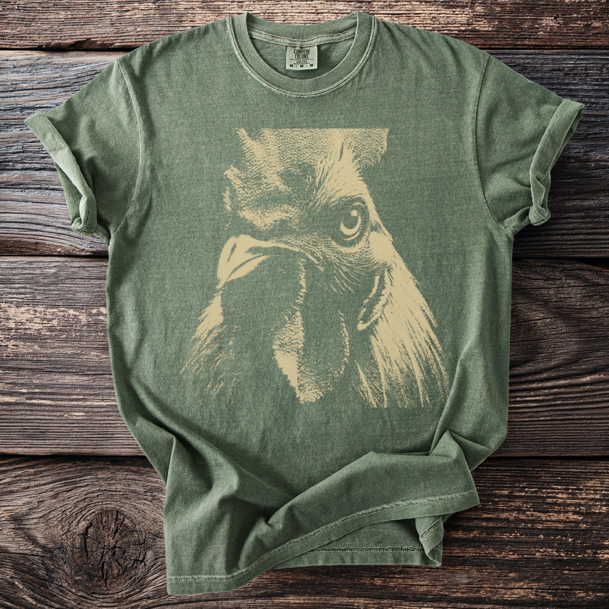 Olive green t-shirt featuring a close-up graphic of a rooster's face.
