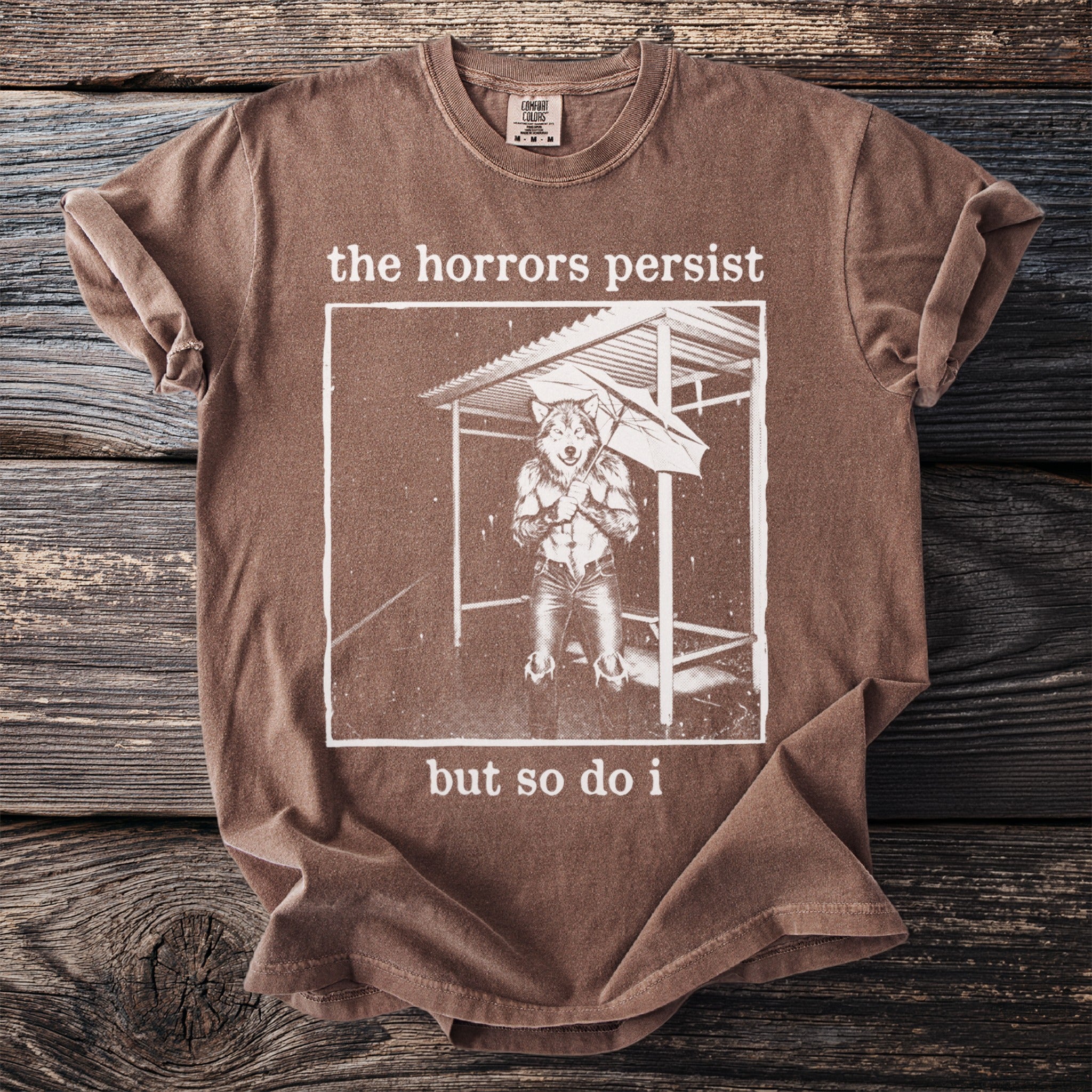 Brown t-shirt with white graphic of a wolf holding an umbrella in the rain.