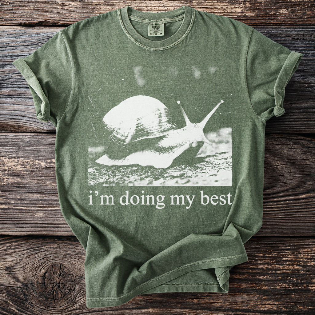 Green t-shirt with white graphic of a snail and text "i'm doing my best".