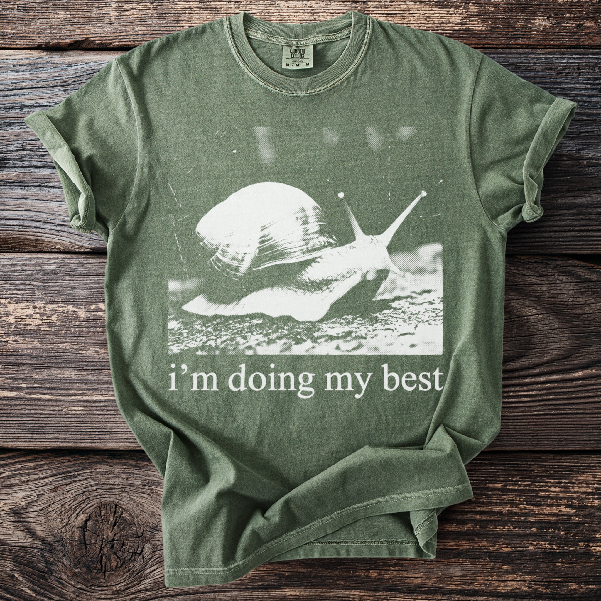 Green t-shirt with white graphic of a snail and text "i'm doing my best".