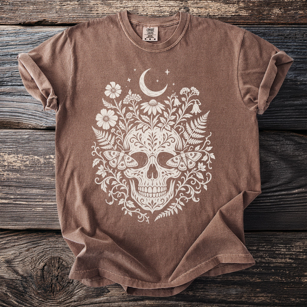 Brown t-shirt with white skull, moth, and floral design, featuring a moon and stars.