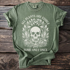 Green t-shirt with a skull, mushrooms, bones, and poison bottle design.