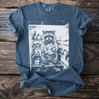 Raccoon holding food inside an open refrigerator printed on a blue t-shirt.