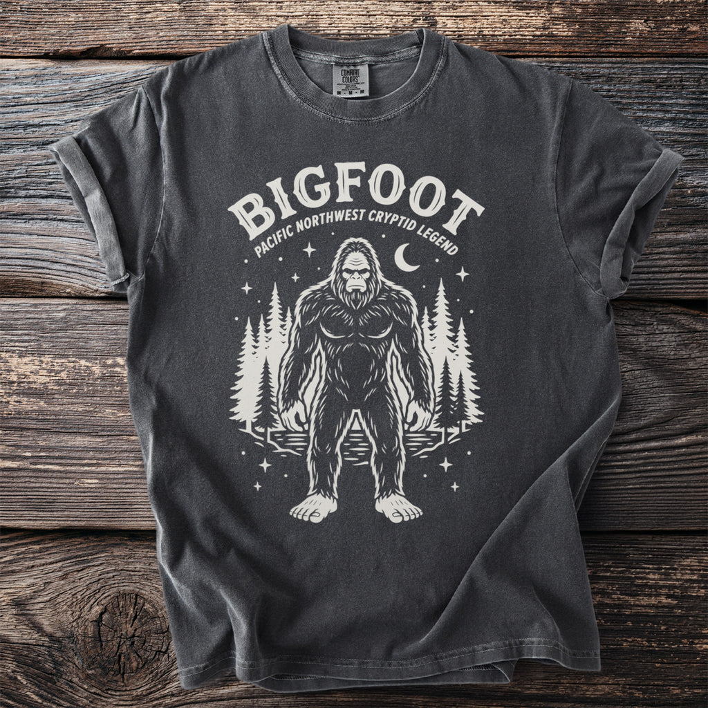 Bigfoot graphic tee with text "Bigfoot Pacific Northwest Cryptid Legend" and trees.