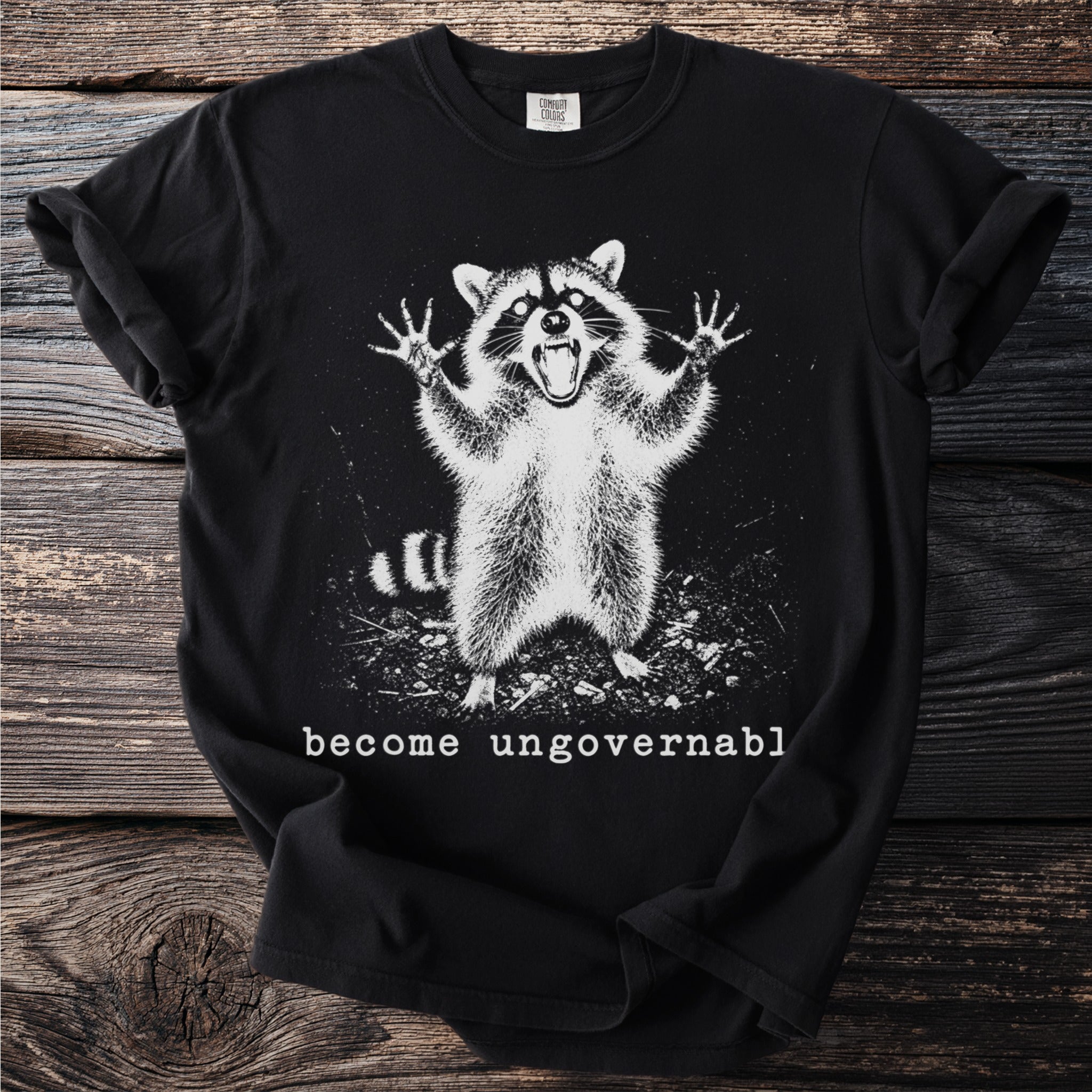 Black t-shirt with a startled raccoon graphic and the text "become ungovernable".