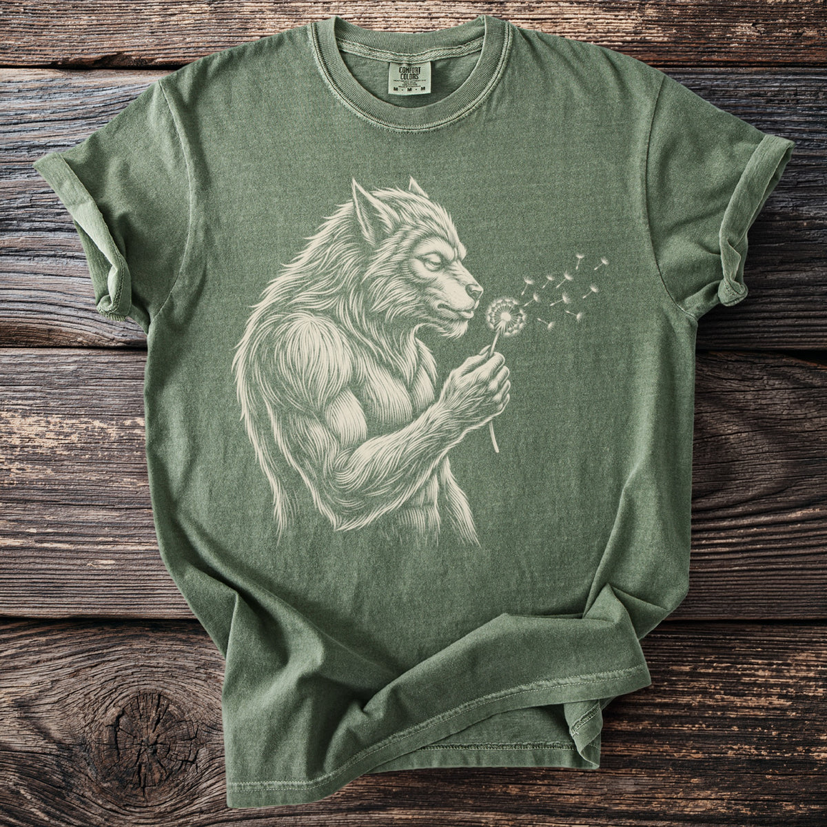 Green t-shirt with a cream line drawing of a werewolf blowing on a dandelion.