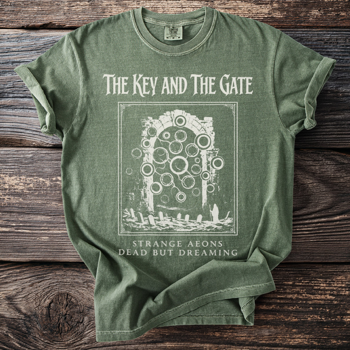 Green t-shirt with "The Key and The Gate" and abstract gate graphic.