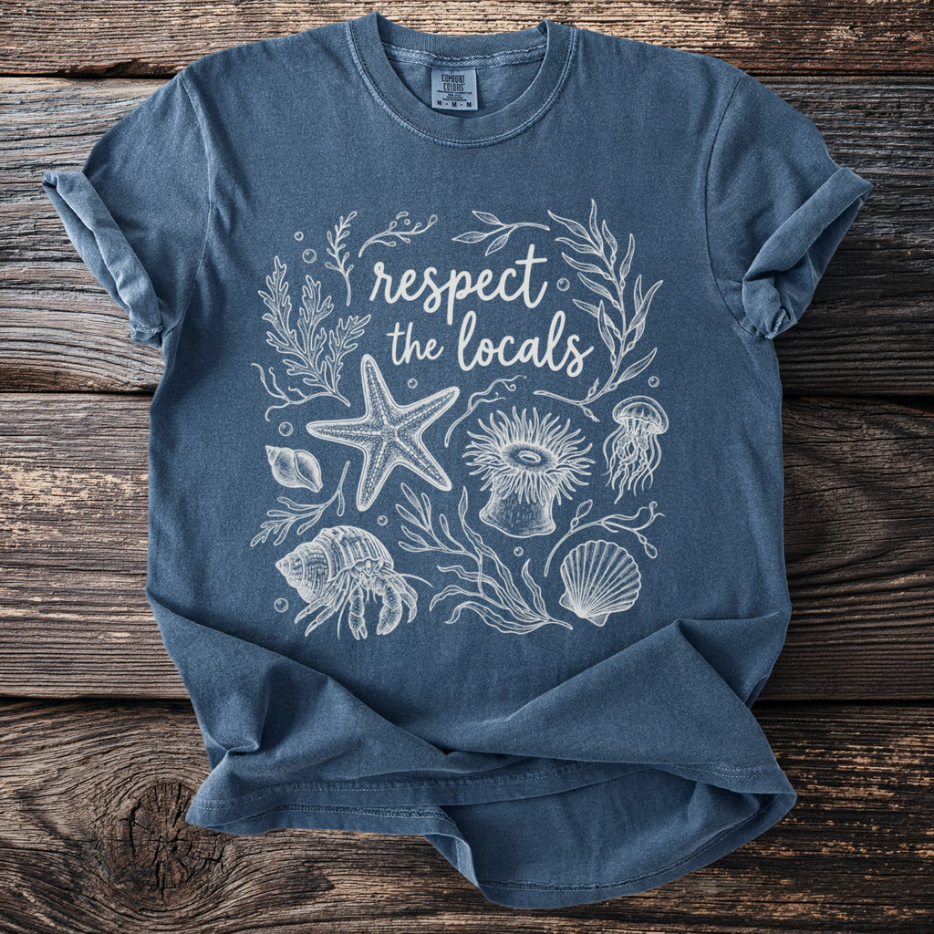 Blue t-shirt with white line art of sea creatures and text "respect the locals".