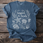 Blue t-shirt with white line art of sea creatures and text "respect the locals".