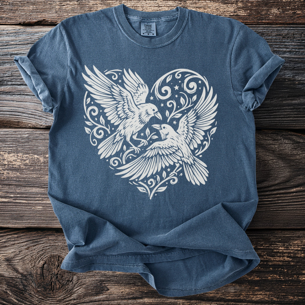 Blue t-shirt with white heart design featuring two ravens and floral elements.